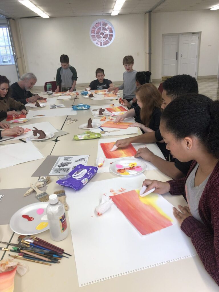 Group Painting Class at the Retreat Group of students painting colorful sunset canvases at an art retreat.