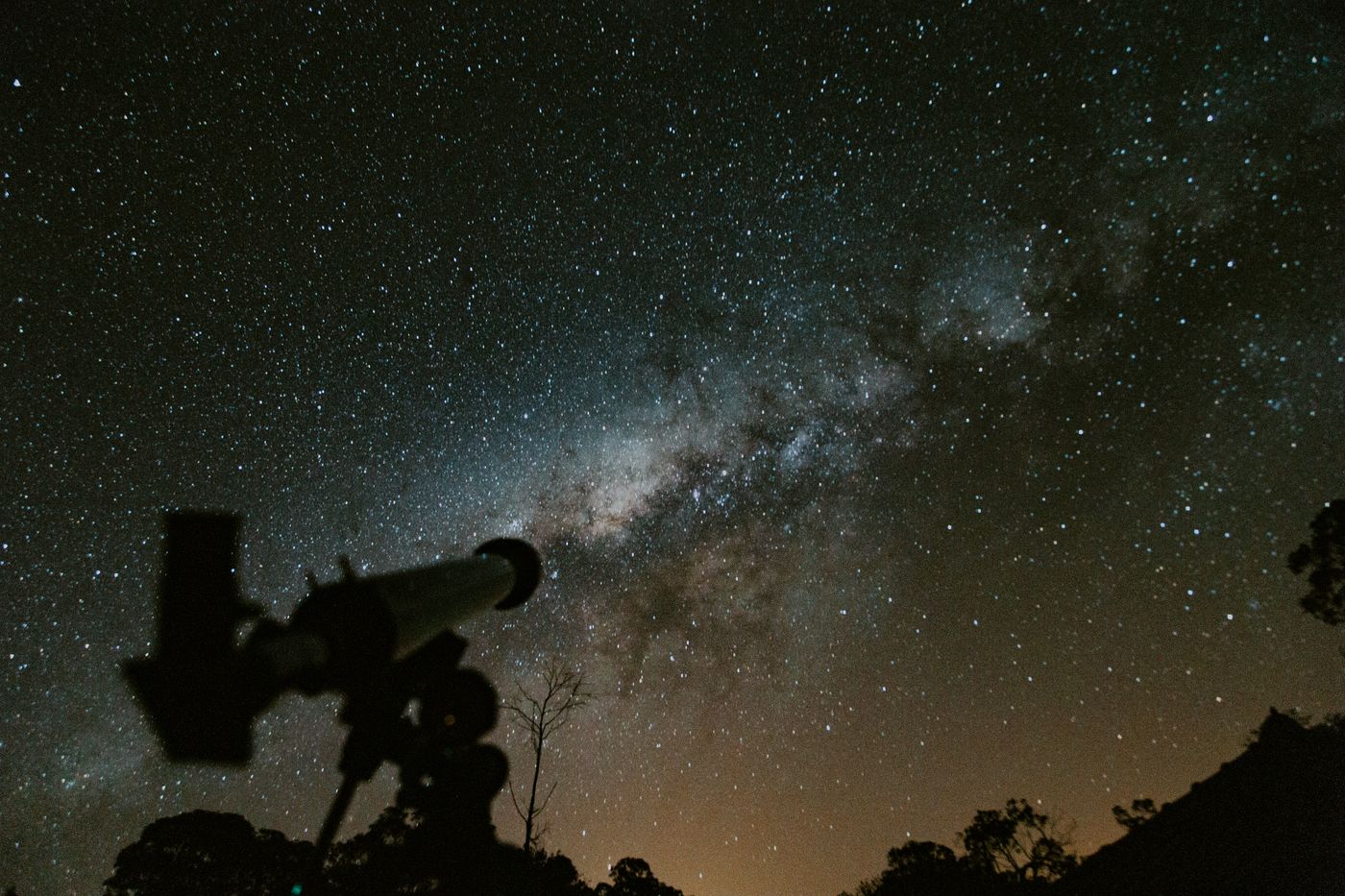 Silhouette of a telescope beneath the Milky Way
